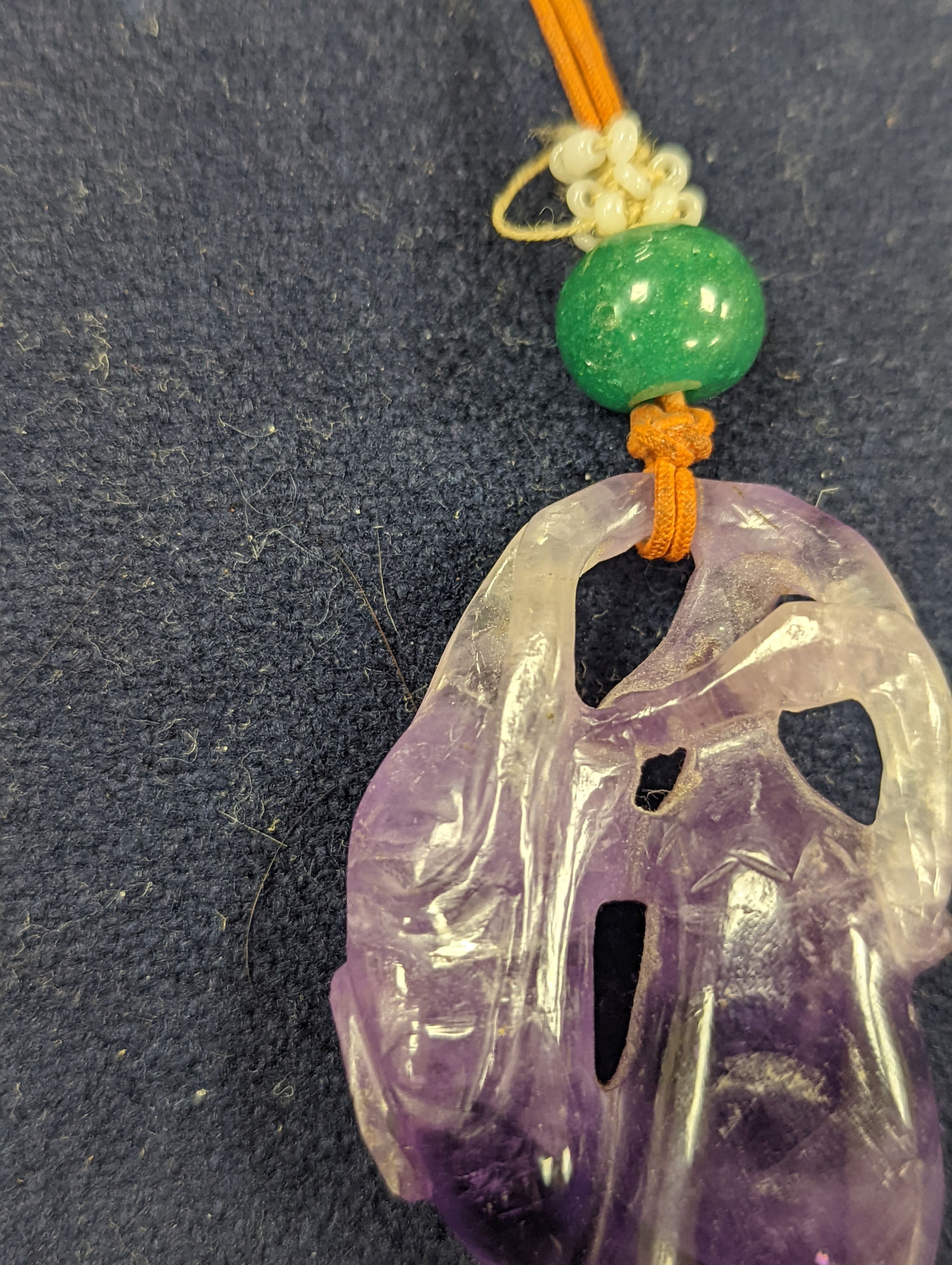A 19th century Chinese carved amethyst pendant, 5cm on an ornate cord